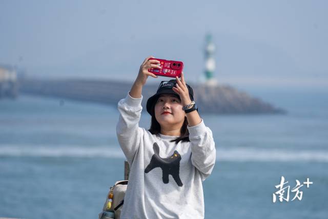 珠海九洲港码头，女孩与灯塔来张合影。南方+记者 钱文攀 摄